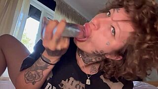 This tatted girl gives a rough blowjob using a dildo until she cries