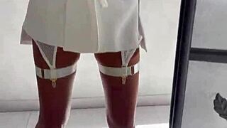 monika fox in white poses in front of mirror before shooting.