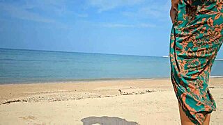 sexy babe in long dress flashes no panties on public beach close-up.