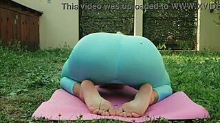 sexy yoga in blue leggings on green meadow