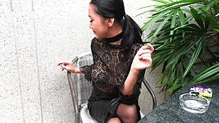 Young goddess smokes topless in leather skirt and heels outdoors