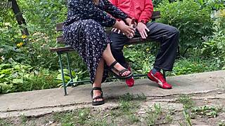 Milf jerks big dick into glass on park bench