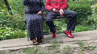 Milf jerks big dick into glass on park bench