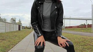 brunette in tight leather leggings with high heels and biker jacket for outdoor fetish style